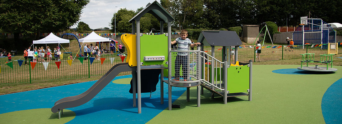 Boy playing on a small multi play unit in green